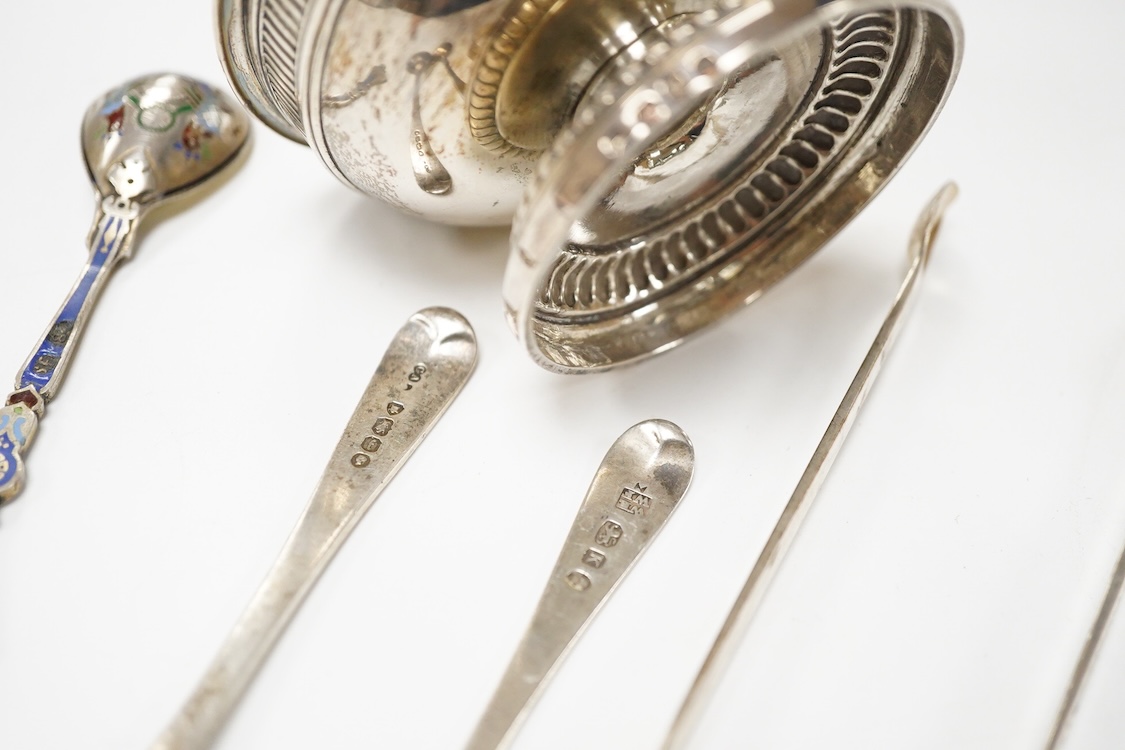 A George III silver pedestal salt, London, 1805, diameter 84mm, together with a pair of Georgian silver sugar tongs, two silver condiment spoons and a Russian 84 zolotnik and polychrome cloisonne enamel spoon, 11.1cm.